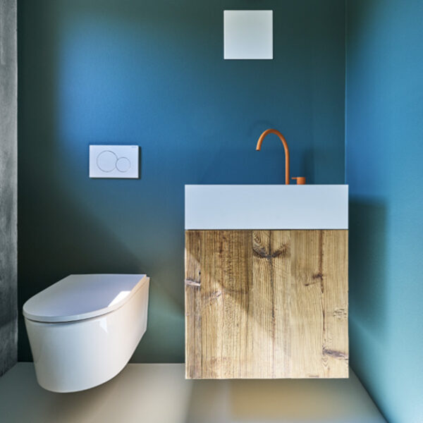 WC mit modernem Waschtisch und orangefarbener Armatur
