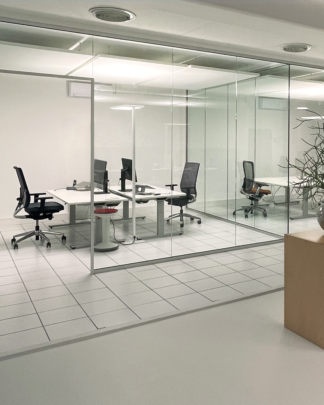 Blick in ein durch Glaswände abgetrenntes Büro